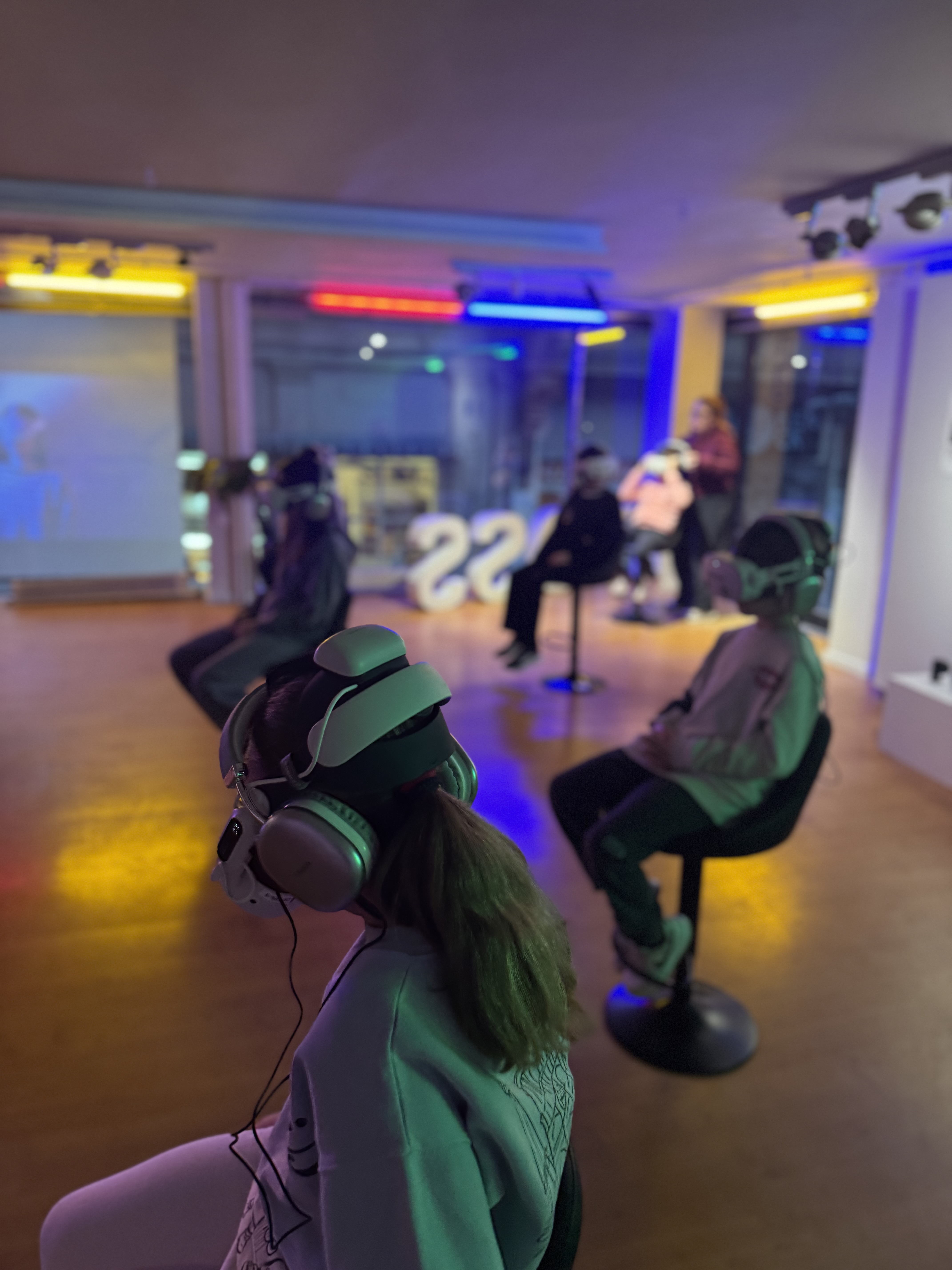 Visitors watching VR in a colorful multi-station room
